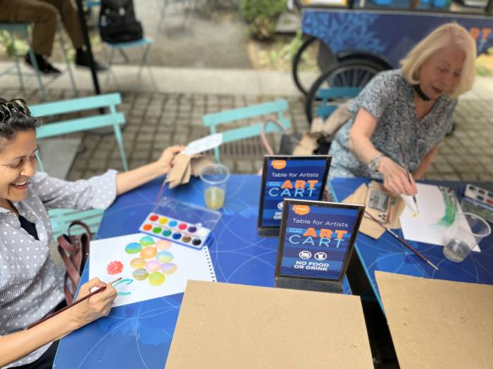 Two women participating in a watercolor workshop at the Art Cart in Bryant Park.
