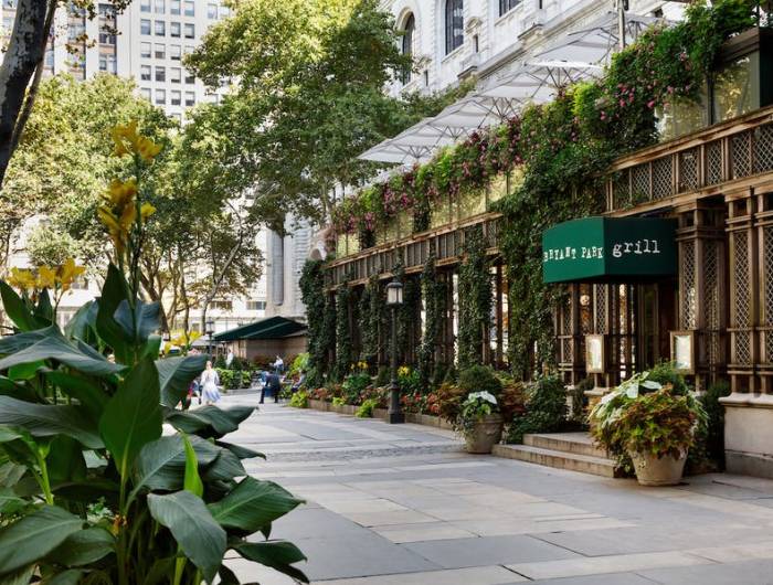 A view of the outside of the verdant and beautiful Bryant Park Grill in summer in Bryant Park NYC.