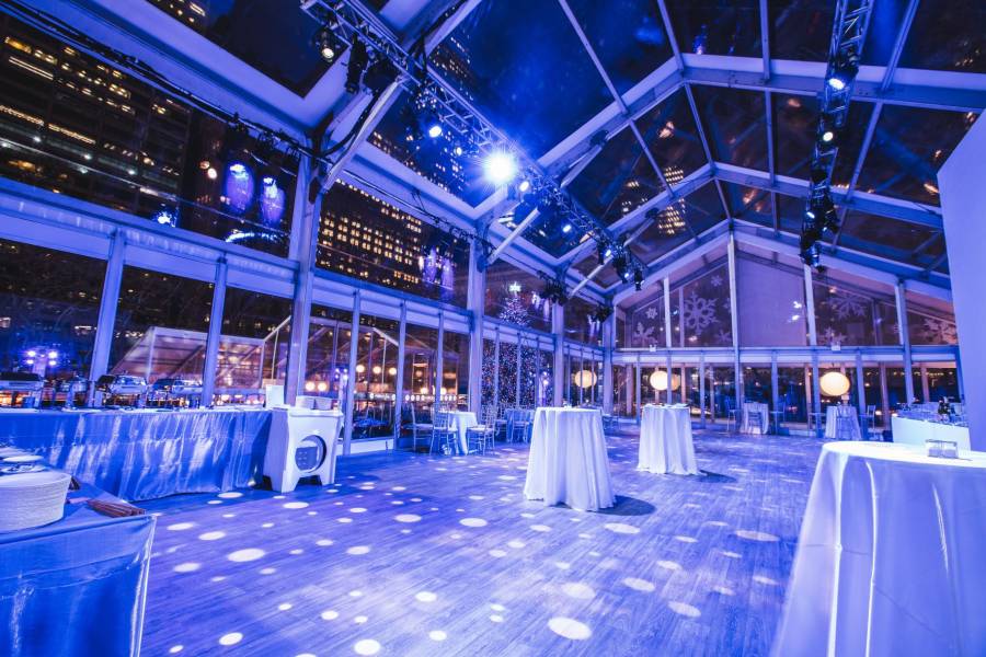 Private event space Overlook at Bank of America Winter Village at Bryant Park, set up and glowing blue for an event.