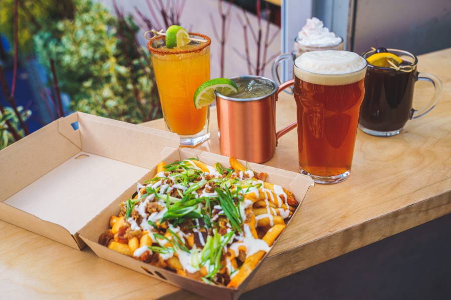 Nachos, beer, and winter drinks sit on a table overlooking the rink at Bank of America Winter Village at Bryant Park in New York City.
